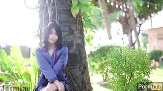 An Asian girl masturbates in the garden using a dildo and vibrator