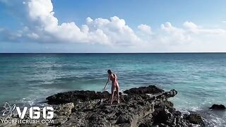 A hot and sexy girl is playing on a naked beach