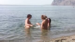 Three naked girls on the crest of a public beach