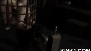 The slave is locked in a cage and obeying all orders of the mistress
