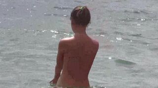 A group of naked people have fun on the beach in a very naughty way