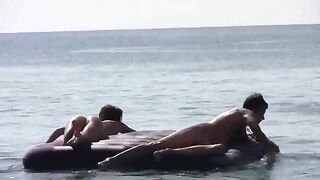 A woman sunbathes naked on the sandy coast, caressed by waves