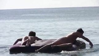 A woman sunbathes naked on the sandy coast, caressed by waves