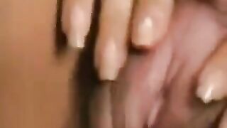 A girl with a big clitoris plays with her hairy pussy