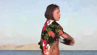 A member shows a naked girl on the beach, showcasing her assets