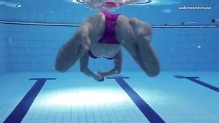 A hot naked girl is swimming in the pool under water