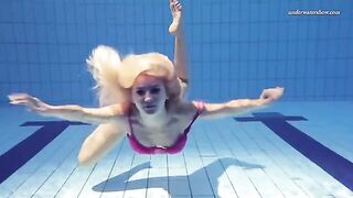 A hot naked girl is swimming in the pool under water
