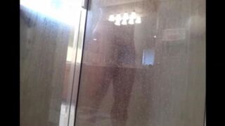A guy washes his body in the shower, not suspecting a thing