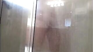 A guy washes his body in the shower, not suspecting a thing