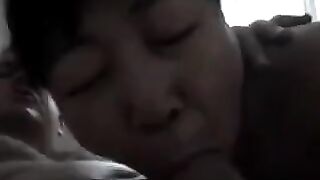A Chinese woman practices her blowjob skills on him, showcasing her passion in a steamy homemade scene
