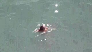A naked couple enjoying sex on the seashore