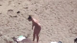 A naked couple enjoying sex on the seashore