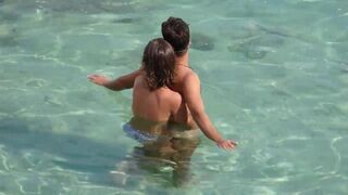 A girl fingers a guy’s cock while they are underwater