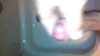 The kid caresses his cock with his hand in the shower