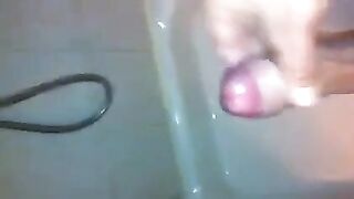 The kid caresses his cock with his hand in the shower