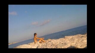 A young girl sunbathes naked on the beach, it's not forbidden
