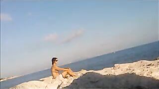 A young girl sunbathes naked on the beach, it's not forbidden