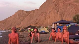 A group of naked beauties playing volleyball on the beach